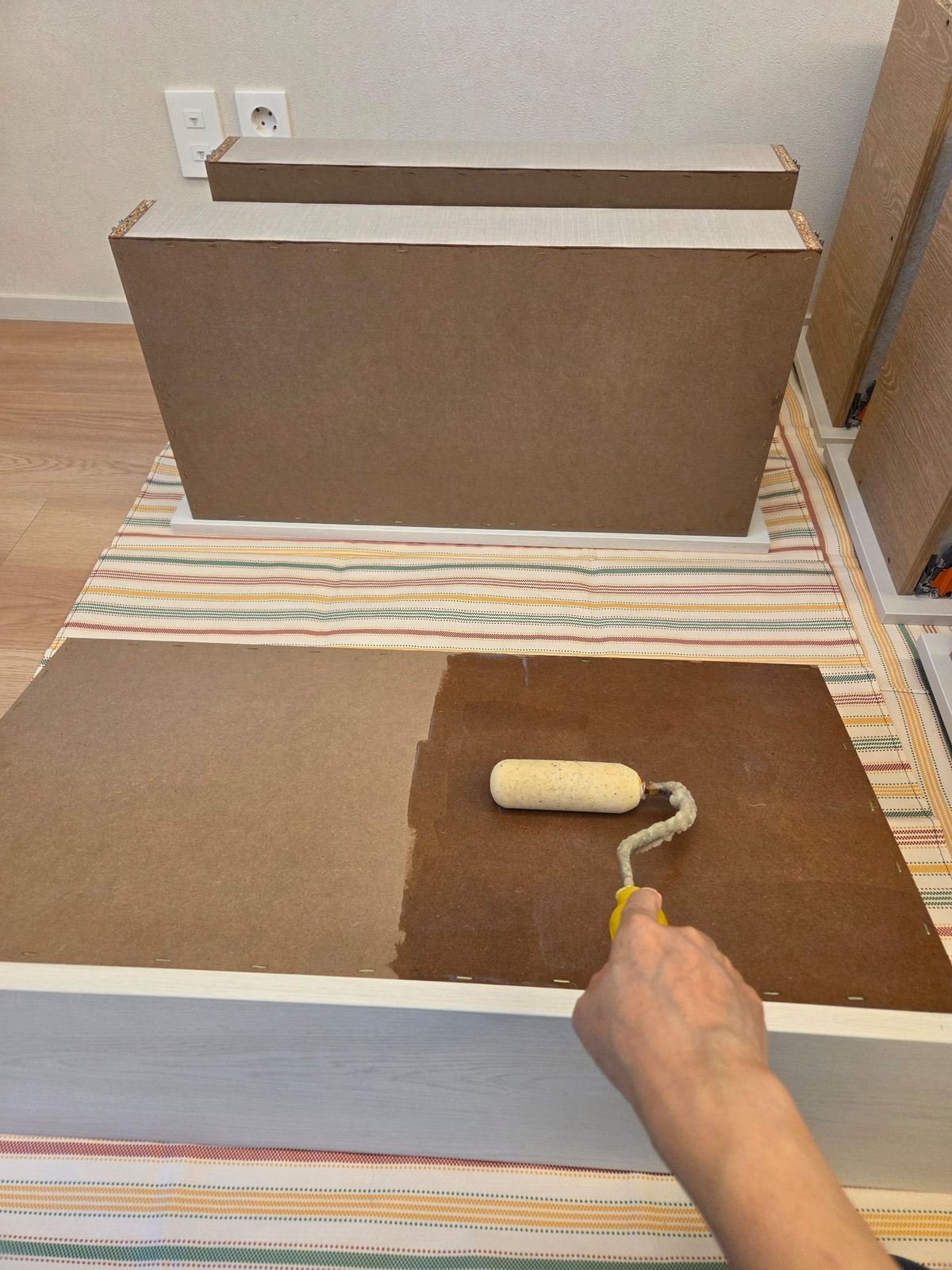 서랍 밑면 MDF 노출 부위에 차폐제를 적용하는 모습